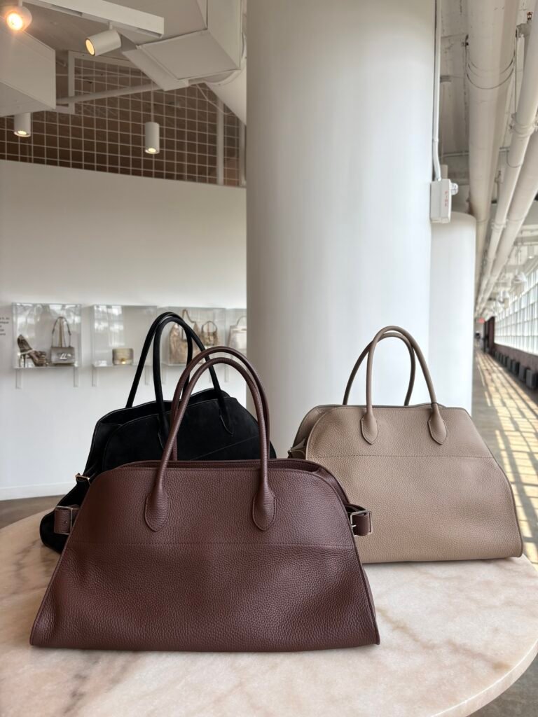 The Row Margaux top-handle bags in black, brown, and taupe.